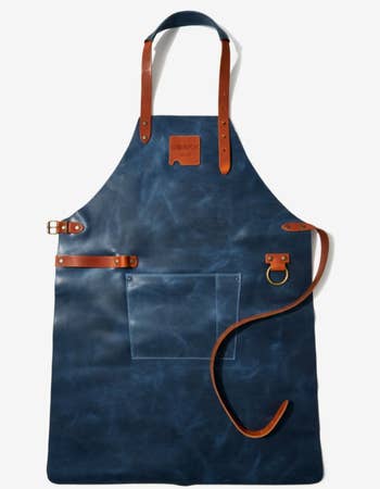 the blue leather apron with stainless steel hardware and brown leather details