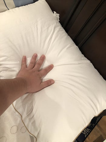 Hand pressing on the pillow
