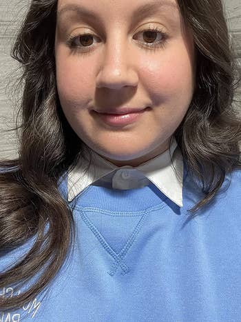 Reviewer wearing white detachable shirt collar with a light blue sweater