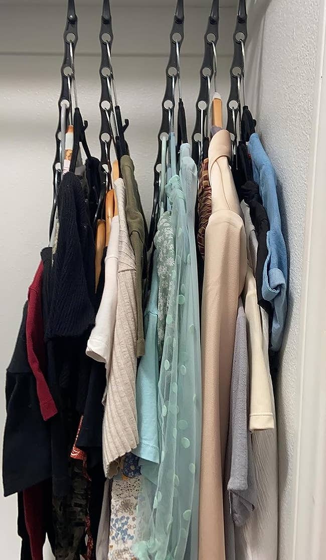 five space saving hooks with hangers inserted in them in reviewer's closet