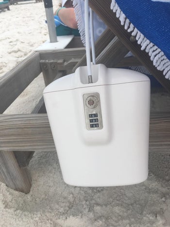 reviewer photo of the white lock box attached to a wooden beach chair