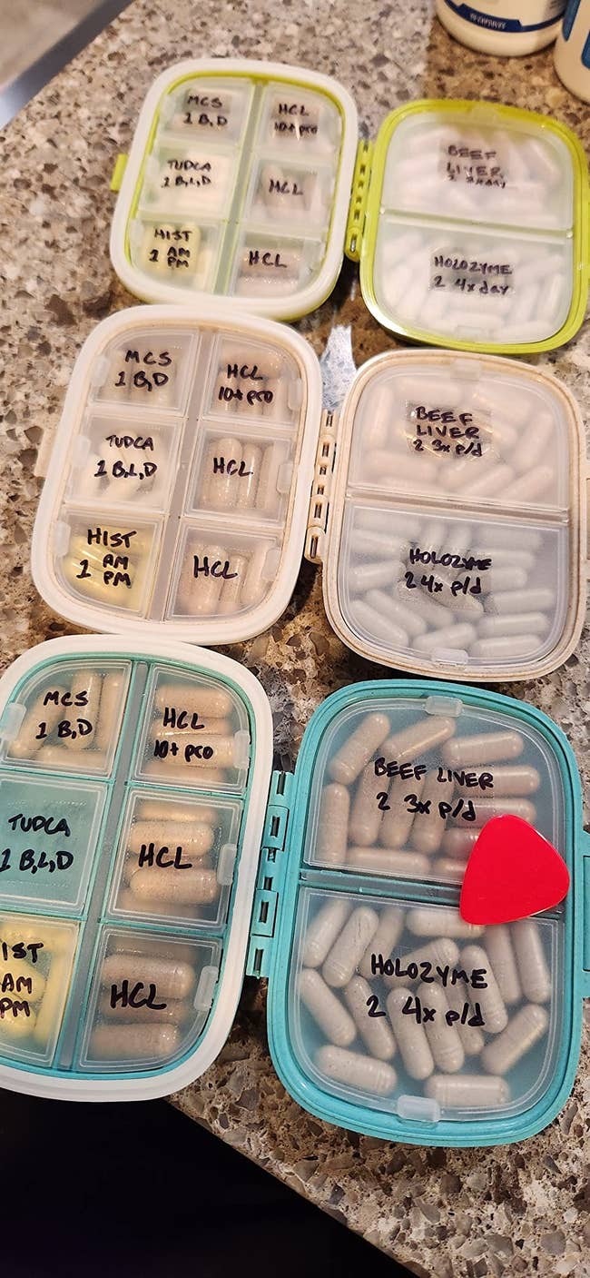 Three pill cases filled with pills