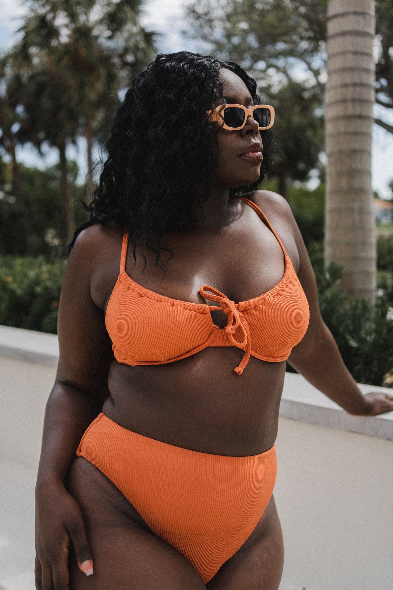 model wearing orange bikini set