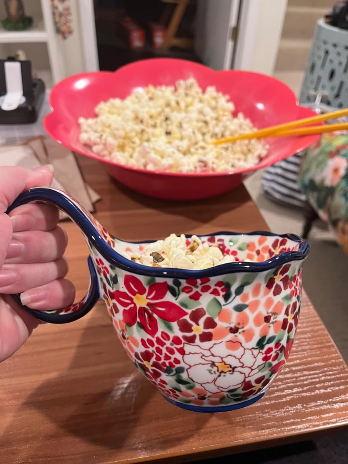 Popcorn being served from a colorful floral bowl with a handle