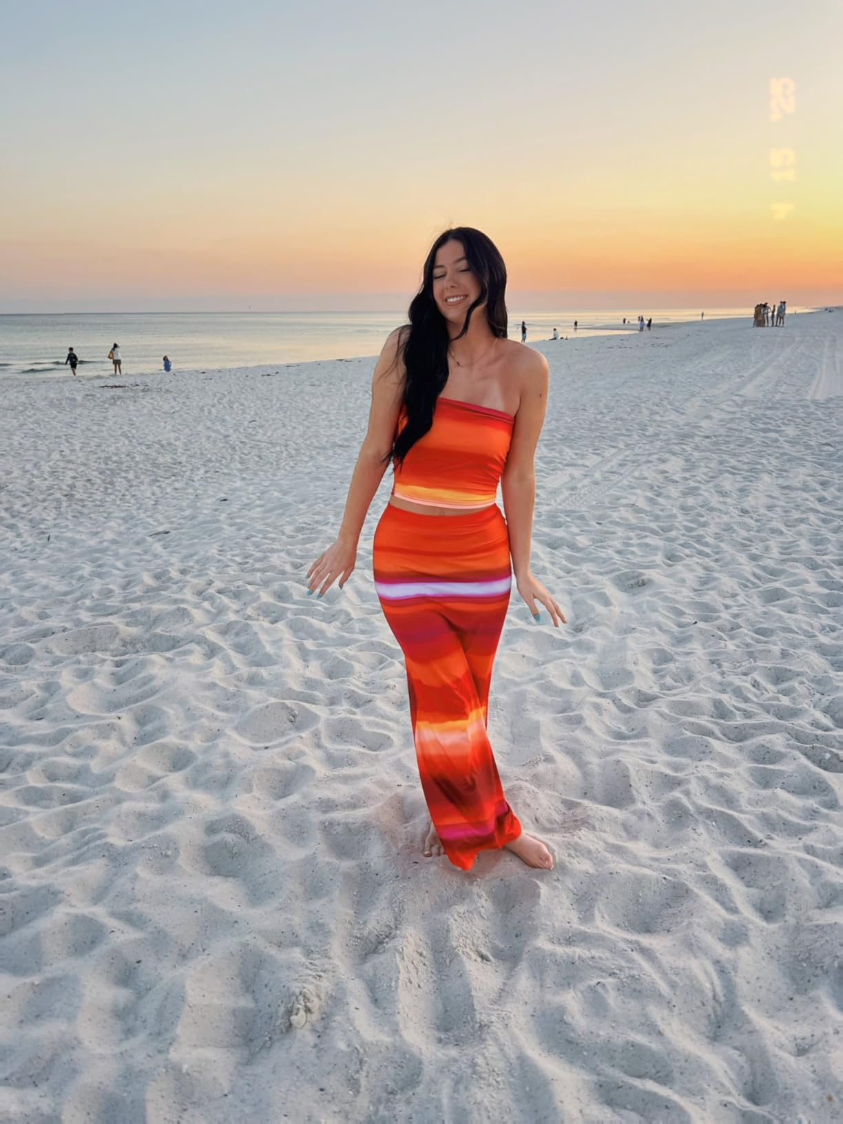 Person connected  formation  astatine  sunset successful  a strapless, body-hugging, striped outfit