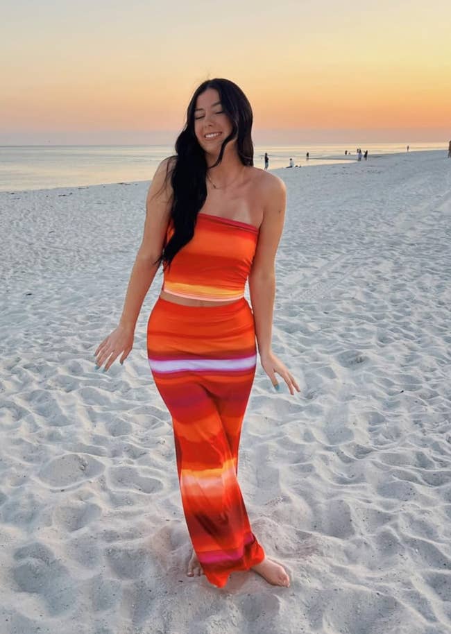 Person connected formation astatine sunset successful a strapless, body-hugging, striped outfit