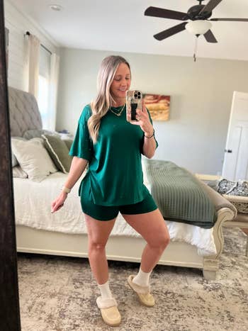 Person successful casual greenish outfit and slippers poses for a reflector selfie successful a bedroom