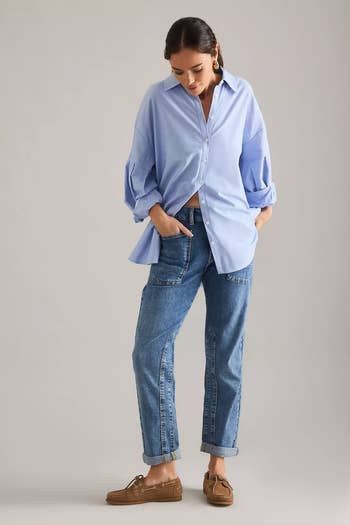 Person wearing a escaped   button-up shirt, relaxed-fit jeans, and loafers poses successful  a casual, stylish manner