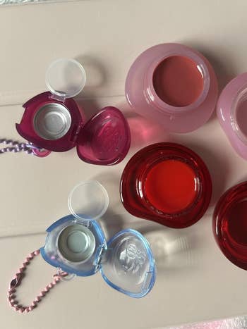 Heart-shaped articulator  balms and reddish  articulator  gloss pots displayed connected  a array  for a buying  article