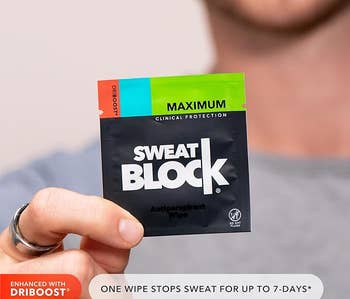 person holding up SweatBlock packet with wipe inside