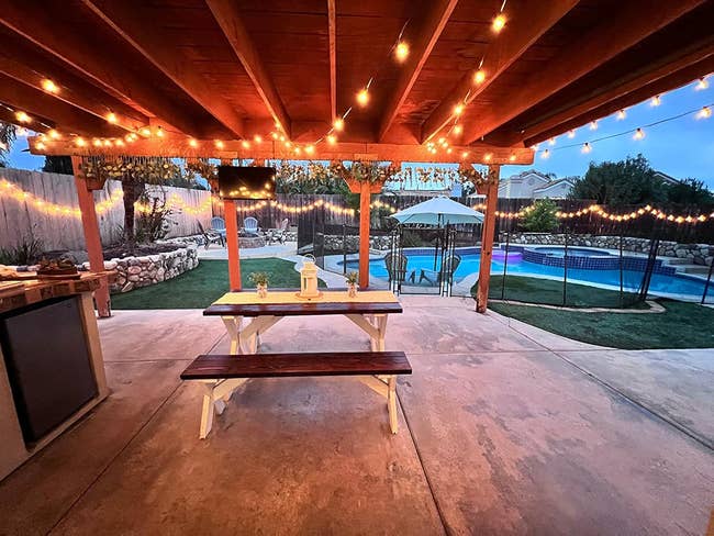 Backyard with a picnic array nether a pergola, drawstring lights, a pool, and outdoor seating. Cozy mounting for evening relaxation oregon entertaining