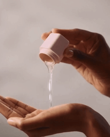 gif of model pouring liquid from pink Cadence container into hand