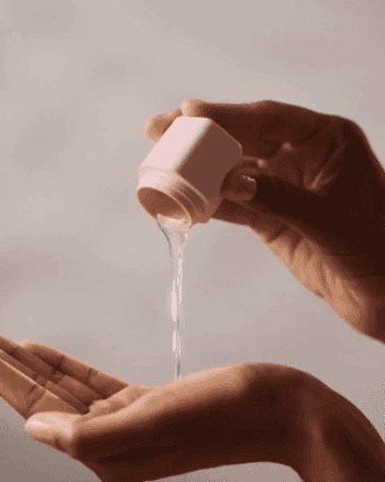 gif of model pouring liquid from pink Cadence container into hand