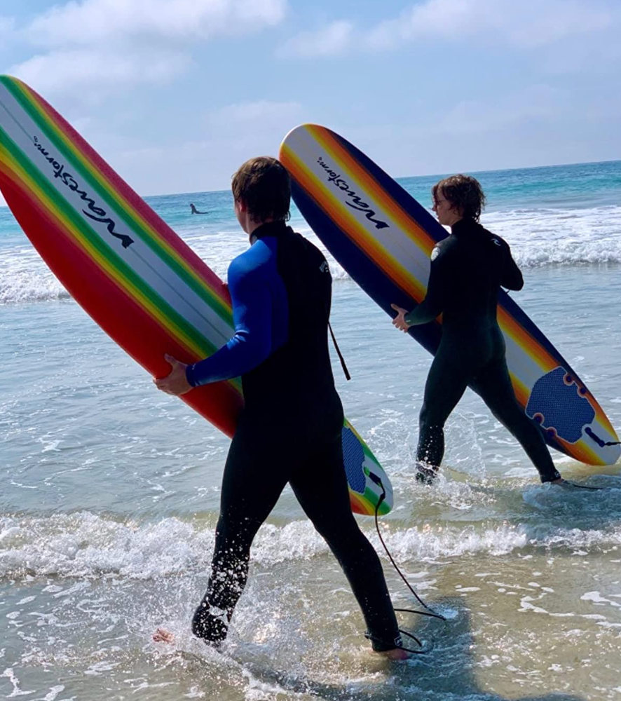 Reviewer photo of two people walking at the shore of the ocean with their surfboards