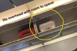 reviewer photo of suitcase in overhead compartment on plane