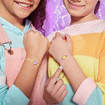 Two models showing their BFF bracelets on their wrists 