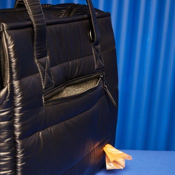 the backside of the bag showing a zipper pocket and the poop-bag dispenser