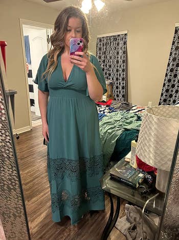 reviewer in the mirror wearing teal dress 