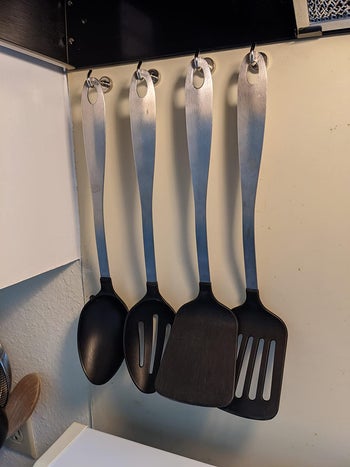 a reviewer using the hooks to hold cooking utensils