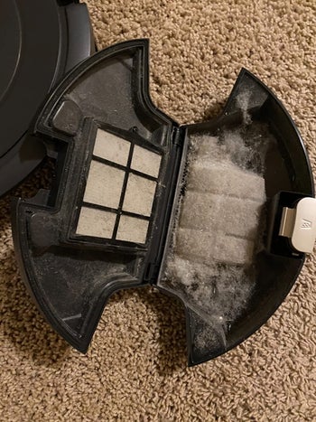 the same reviewer showing the inside of the robot vacuum and how much dust and dirt it vacuumed up