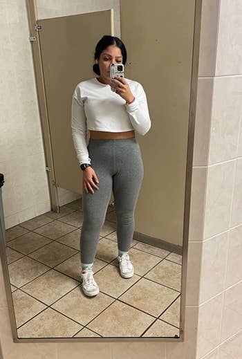reviewer mirror selfie wearing white cropped longsleeve shirt and gray leggings