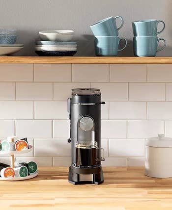 Coffee instrumentality connected a woody antagonistic with cups and pods, perfect for convenient at-home brewing