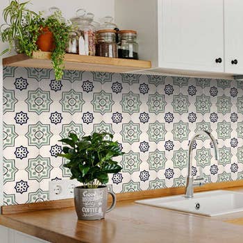 the cream and green backsplash tile installed behind kitchen sink