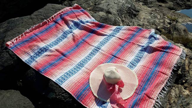 reviewer photo of serape woven blanket on some rocks