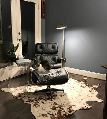 a brown and white cowhide rug under a black office chair