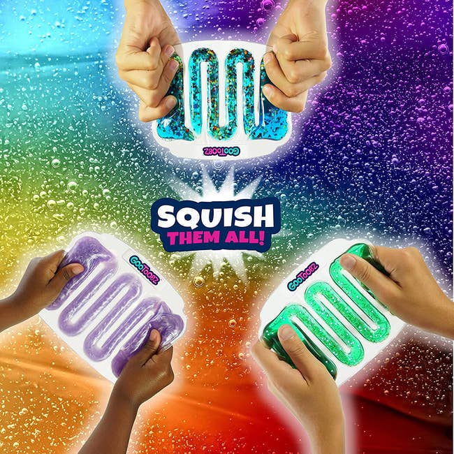 Hands playing with three different colored squish toys