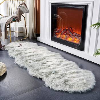Grey rug next to a fireplace