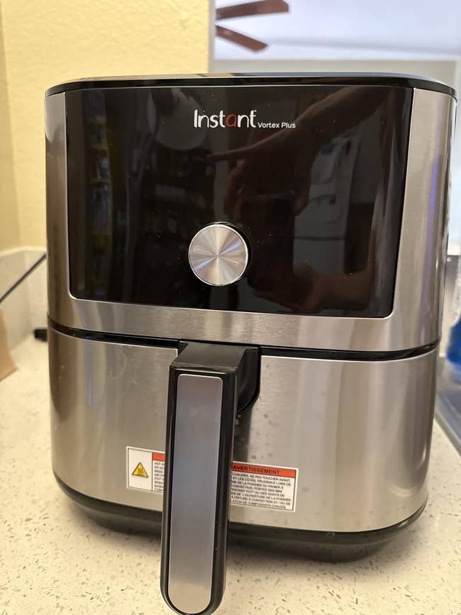 Instant Vortex Plus aerial fryer connected a room counter, featuring a sleek, modern plan with a integer interaction show and a ample beforehand handle
