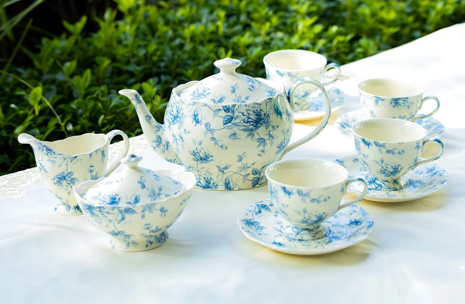 Blue and white floral porcelain tea set on a white tablecloth 