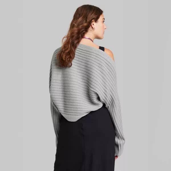a back view of the model wearing the same sweater in gray 