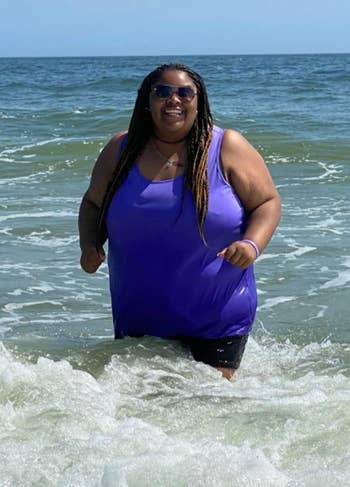 Reviewer wearing a purple tank top in the ocean 