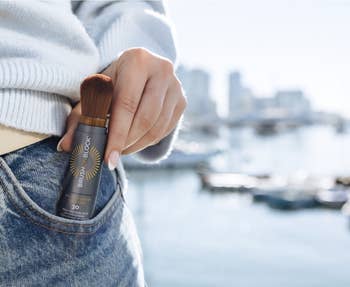 Model putting Brush On Block Powder sunscreen successful pocket