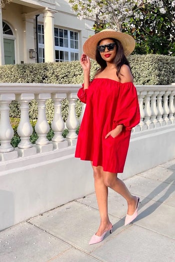 a model wearing a red off the shoulder dress