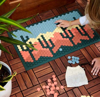 model creating a desert design on a tile mat