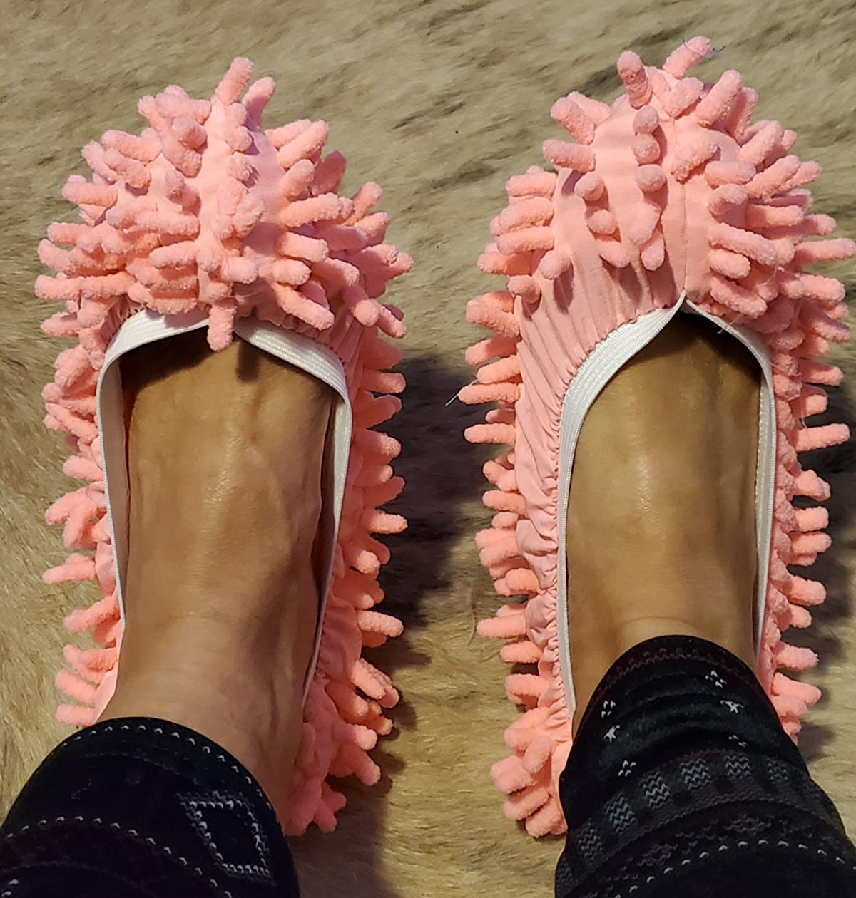 reviewer wearing peach mop slippers on their feet