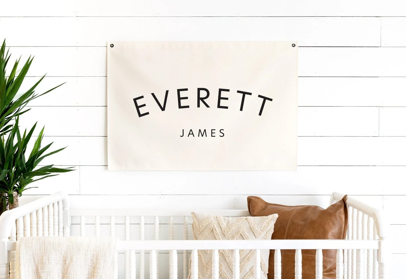 white and natural nursery with rectangular minimalist baby name banner on wall
