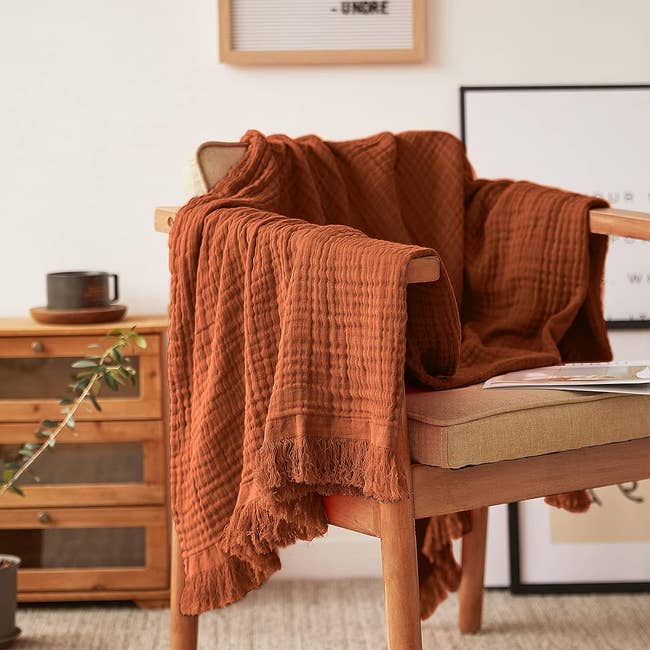 blanket tossed over wooden chair