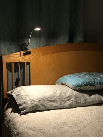 reviewer photo of black clip-on lamp on headboard