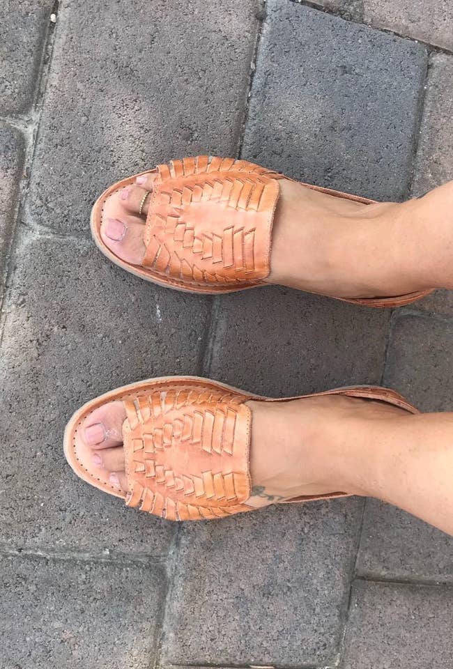 a reviewer wearing tan open toe huarache sandals