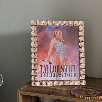 a tan jewel surrounded picture frame with taylor swift in it