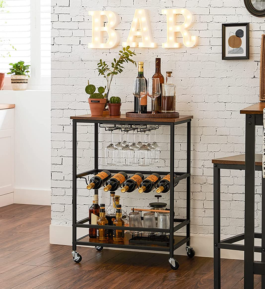 the industrial style bar cart fully stocked with bottles, glasses, and plants