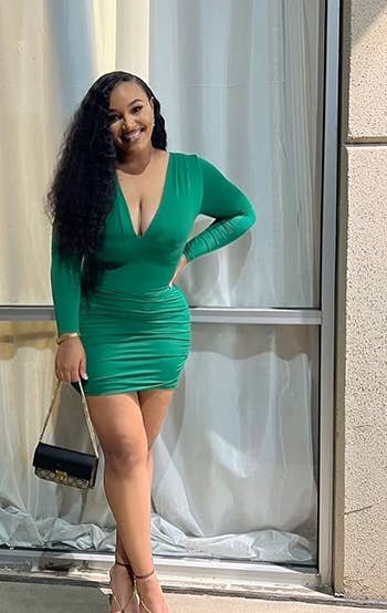 A reviewer wearing the dress in green 