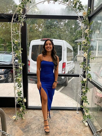 a reviewer in a blue dress with a high slit