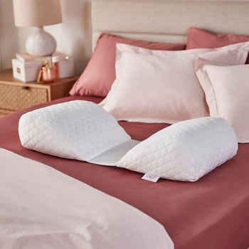 Image of the white pillow on pink sheets on a bed