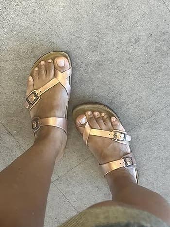 Person wearing stylish strappy sandals, showcasing a casual summertime  footwear option
