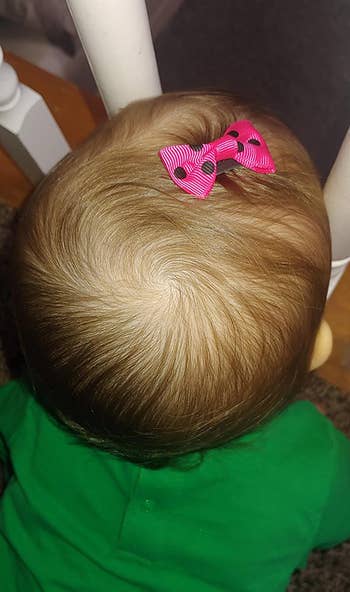 reviewer photo of baby with pink bow in hair